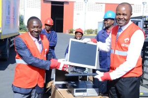 Airtel Kenya Corporate Affairs Director Dick Omondi presents computers to Computer for Schools Founder and Director Dr. Tom Musili.