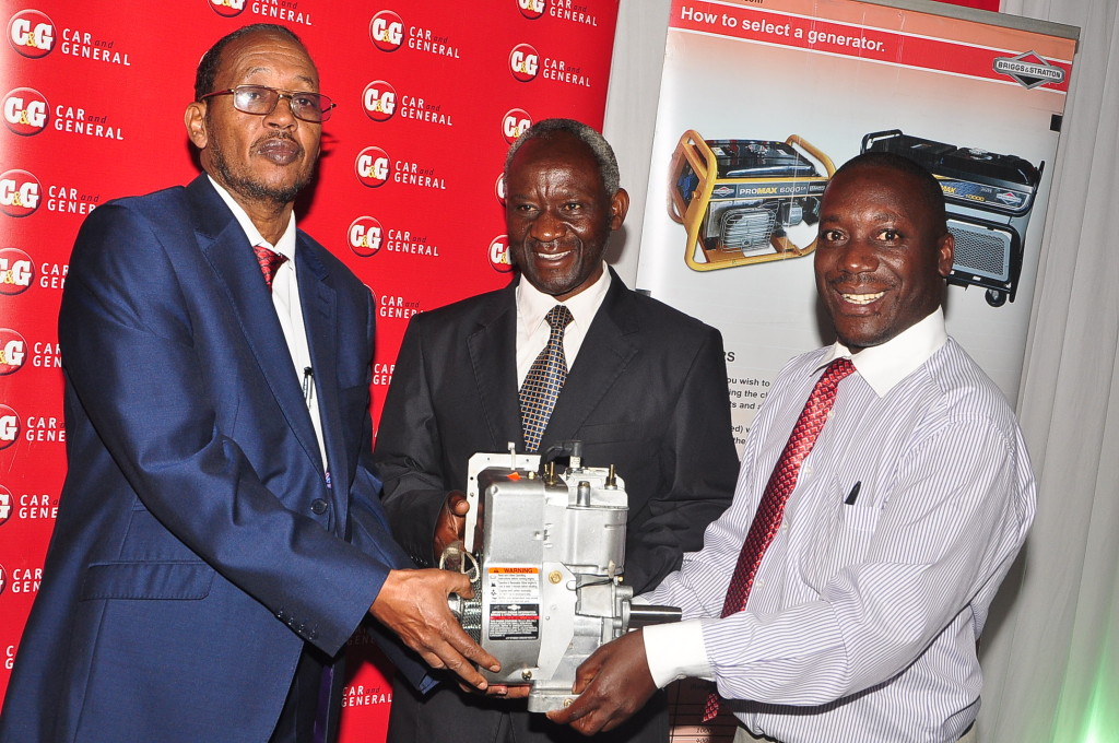 Bashir Mursal (L), Director of Technical Education Raphael Atanda(R), Car & General's Communications and Marketing Manager present an engine to Francis Saya (Center) the Principal, Sikri Institute for the Blind and Deaf during Car and General's annual Engine Donation Program.  