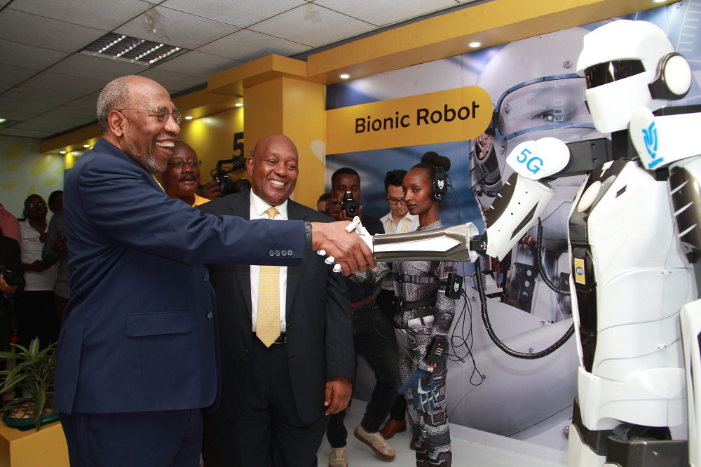 Uganda's Prime Minister Ruhakana Rugunda(L) shakes hands with a robot that uses the 5G network during the 5G technology trial ceremony in Kampala, Capital of Uganda, Jan. 17, 2020