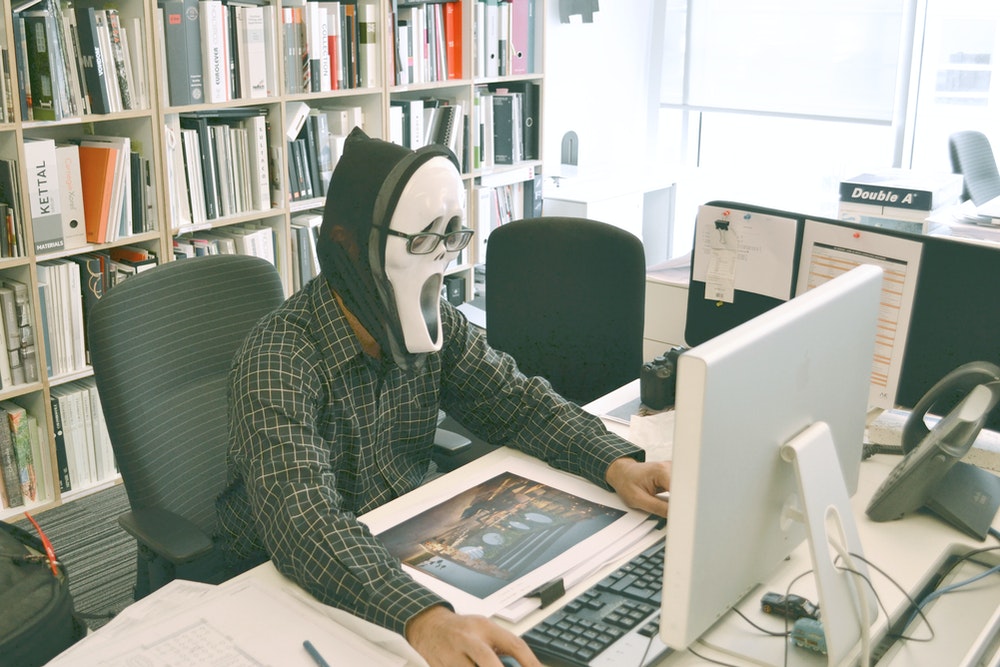 person wearing scream mask and-black hoodie