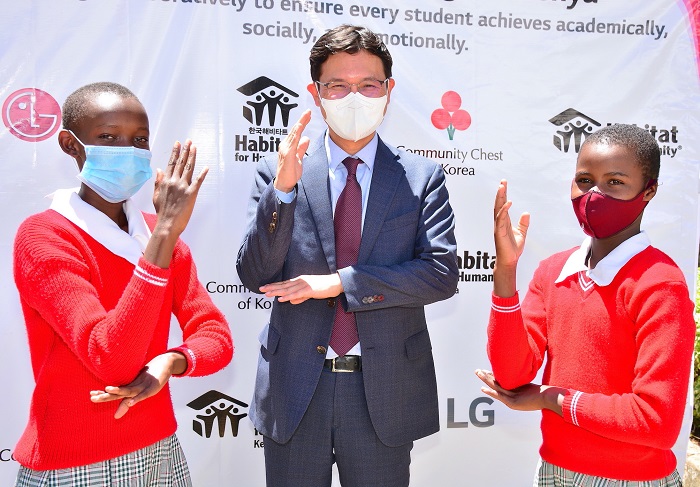 LG Electronics Managing Director for East and Central Africa, Sa Nyoung Kim (centre) is joined by Kanini Mbondo and Magdalene Kamene, class six pupils at the Machakos School for the Deaf.