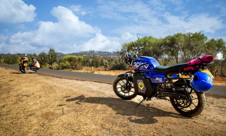 A Spiro electric motorcycle parked along a rural road, illustrating the rise of clean energy mobility attracting venture capital in Kenya.