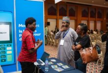 A Moniepoint Inc. representative speaks with attendees at a fintech event, as the company expands through its stake in Sumac Microfinance Bank.