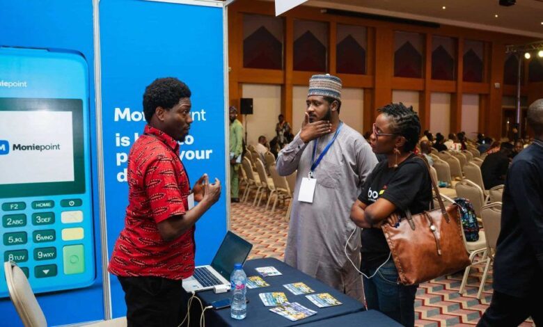 A Moniepoint Inc. representative speaks with attendees at a fintech event, as the company expands through its stake in Sumac Microfinance Bank.