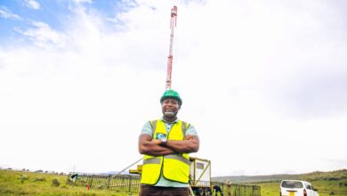 A Safaricom engineer stands beside a Cell on Wheels mobile tower deployed to extend network coverage along the Safari Rally route.