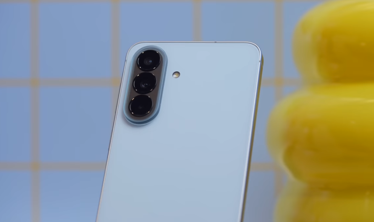 Rear view of the Samsung Galaxy A57 5G in icy blue, showing the vertical triple-camera layout and refined midrange design language.