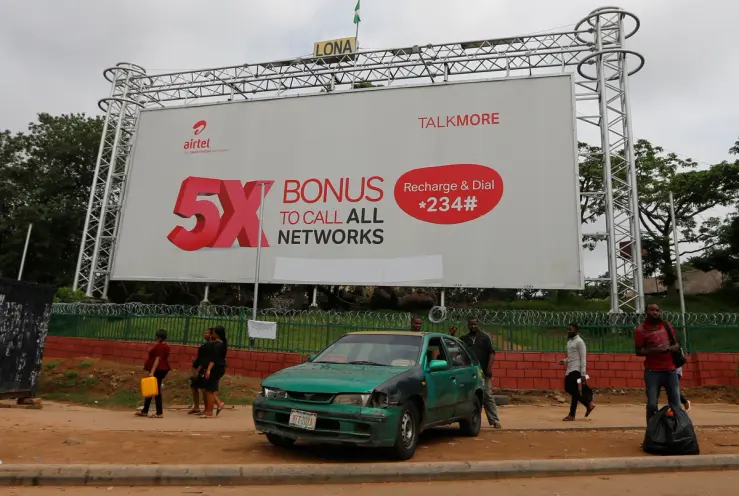 An Airtel advertising billboard stands along a roadside in Lagos, Nigeria. Bharti Airtel is increasing its stake in Airtel Africa through a share swap transaction tied to its African operations.