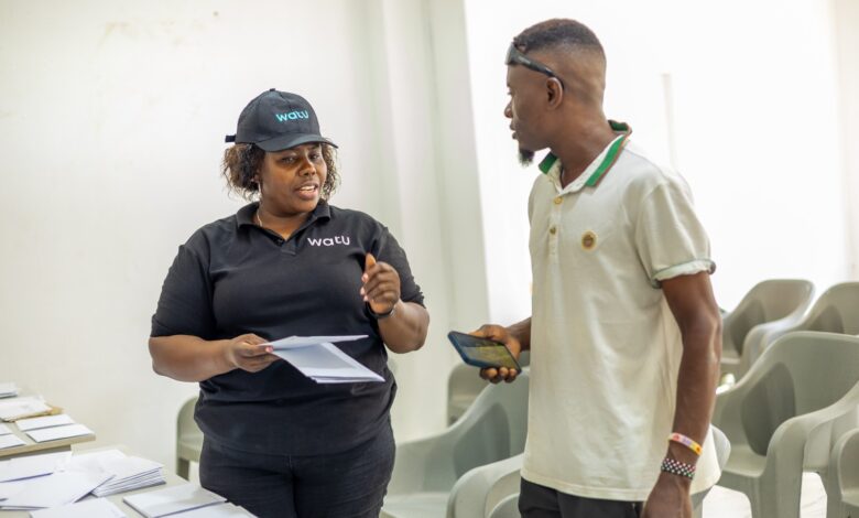 Watu Kenya Coast Regional Manager Mehetabel Mwashighadi hands over a motorcycle logbook to a customer during an asset-financing engagement in Malindi.