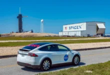 A Tesla vehicle parked near a SpaceX launch facility in Florida, reflecting the growing overlap between Musk’s automotive, aerospace and AI businesses.