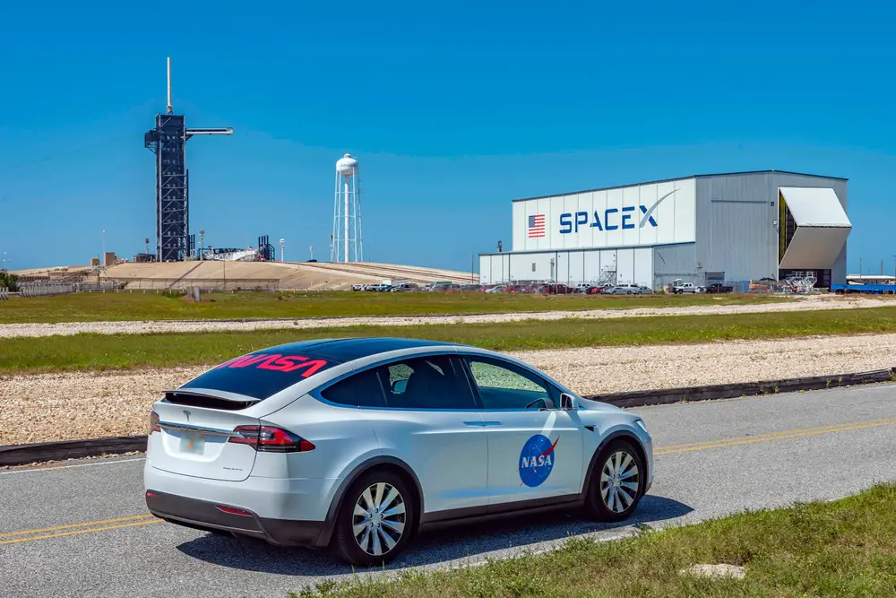 A Tesla vehicle parked near a SpaceX launch facility in Florida, reflecting the growing overlap between Musk’s automotive, aerospace and AI businesses.