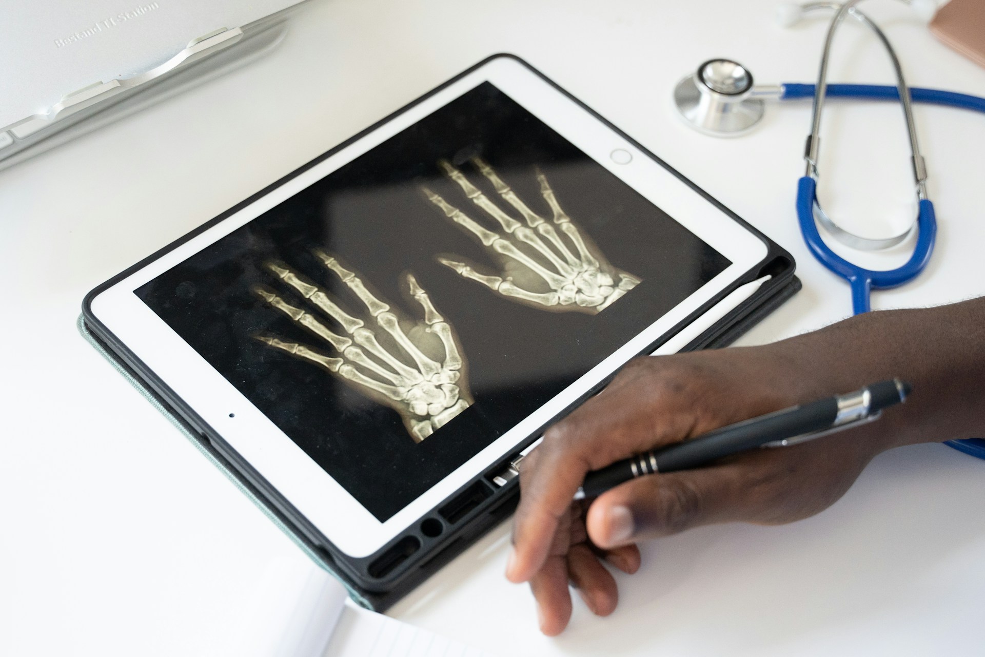 Healthcare professional reviewing X-ray images on a tablet, reflecting the growing use of digital radiology, telemedicine and technology-enabled healthcare services.