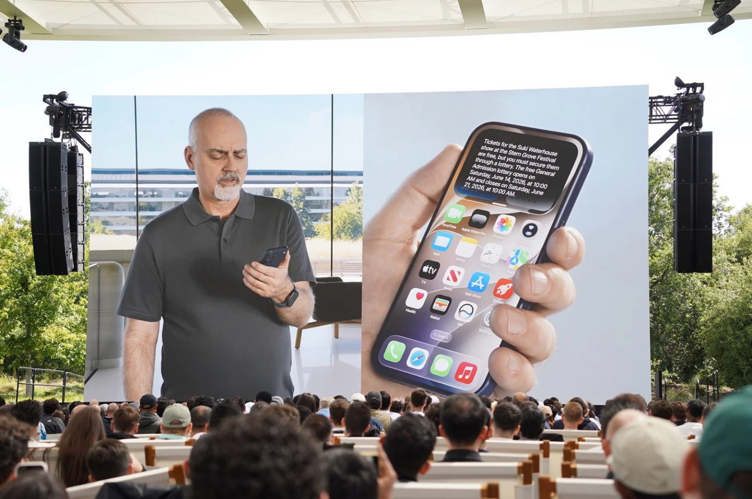 Mike Rockwell presents Apple's new Siri AI features on a large screen during WWDC 2026 as attendees watch from the audience.