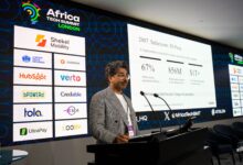 Nadeem Juma presenting at Africa Tech Summit London with slides on M-Pesa, mobile money growth, and African credit infrastructure.