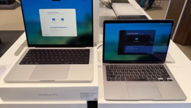 Apple MacBook Pro and MacBook Air displayed side by side on a retail showroom table.