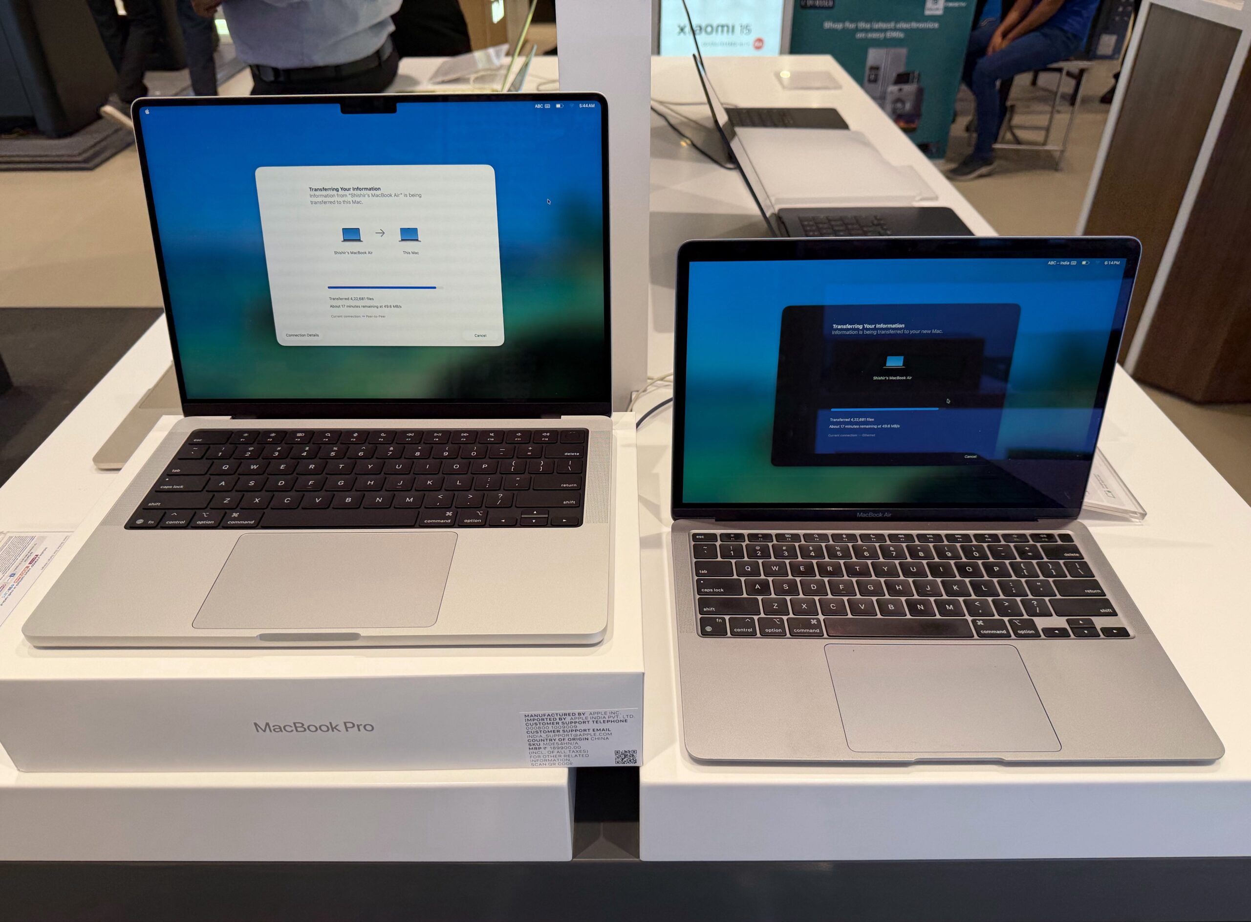 Apple MacBook Pro and MacBook Air displayed side by side on a retail showroom table.