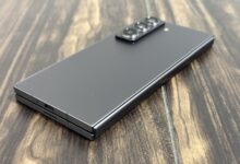 Samsung Galaxy Z Fold8 folded closed on a wooden table, showing its slim profile and rear camera module.