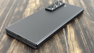 Samsung Galaxy Z Fold8 folded closed on a wooden table, showing its slim profile and rear camera module.