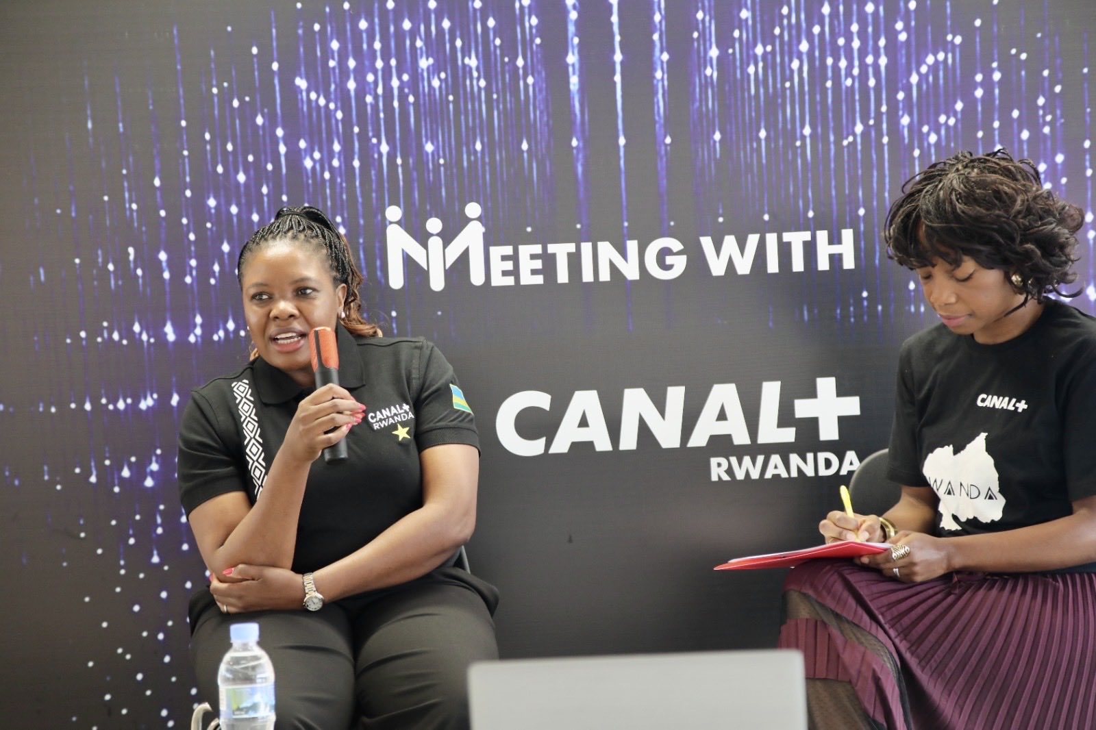 Fhulufhelo Badugela, then a member of Canal+'s Transformation and Integration team, speaks during a CANAL+ Rwanda "Meeting With" session as Sophie Tchatchoua, CEO of CANAL+ Rwanda, takes notes following Canal+'s acquisition of MultiChoice.