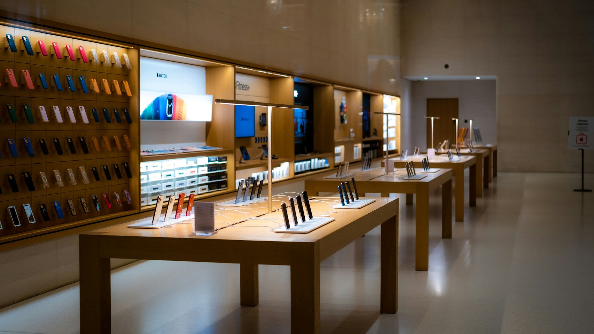 Smartphones and communications devices displayed on tables inside an electronics retail store in Kenya.