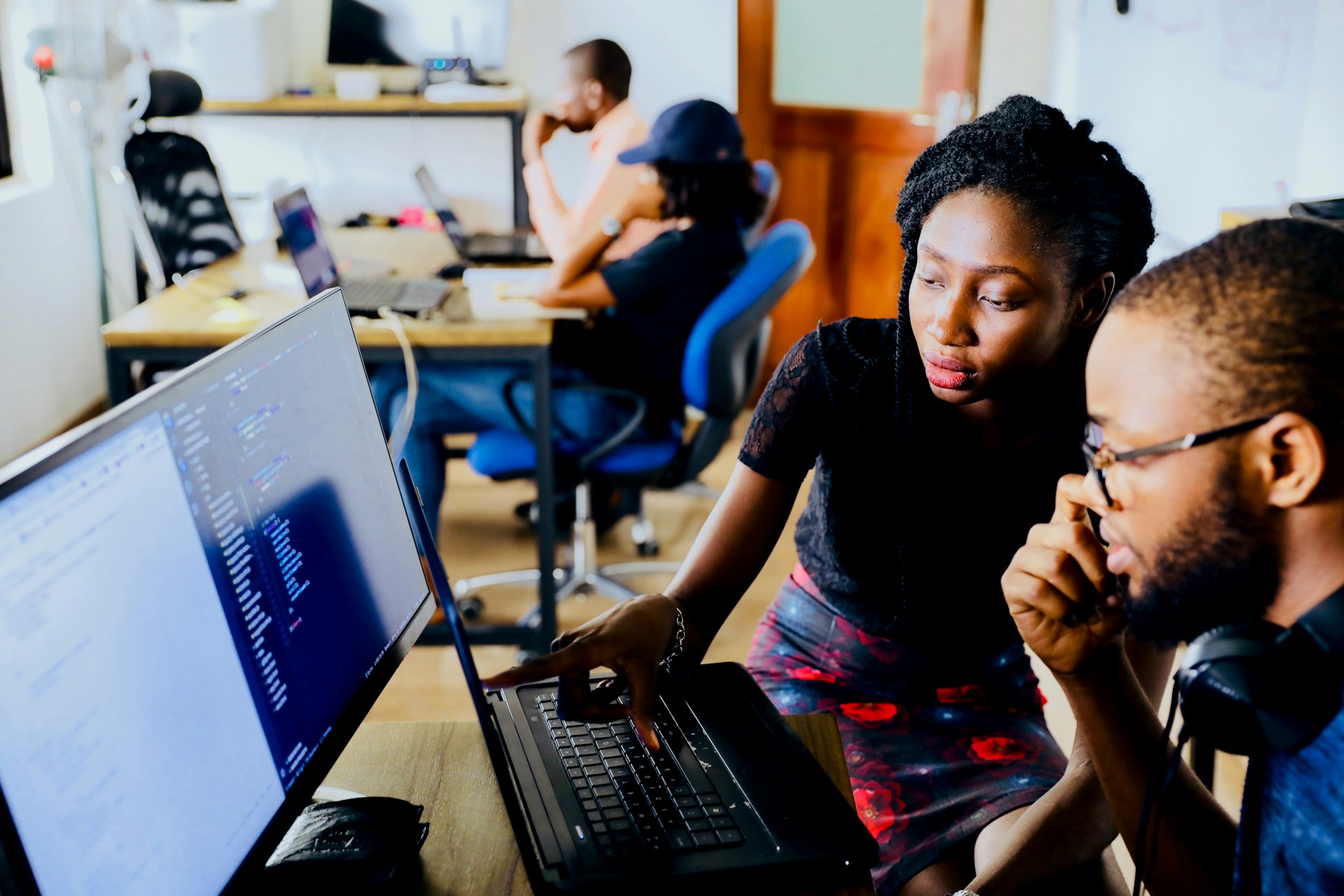 Two small business employees reviewing computer systems as part of a layered cybersecurity strategy that combines endpoint protection, multi-factor authentication and continuous monitoring.