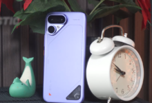 TECNO POVA Curve 2 5G in Mystic Purple showing its slim rear design and dual-camera module beside a white alarm clock.