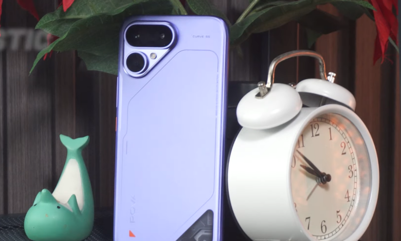 TECNO POVA Curve 2 5G in Mystic Purple showing its slim rear design and dual-camera module beside a white alarm clock.