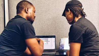Two small business professionals reviewing cybersecurity measures on a laptop as they discuss layered security beyond traditional antivirus protection.
