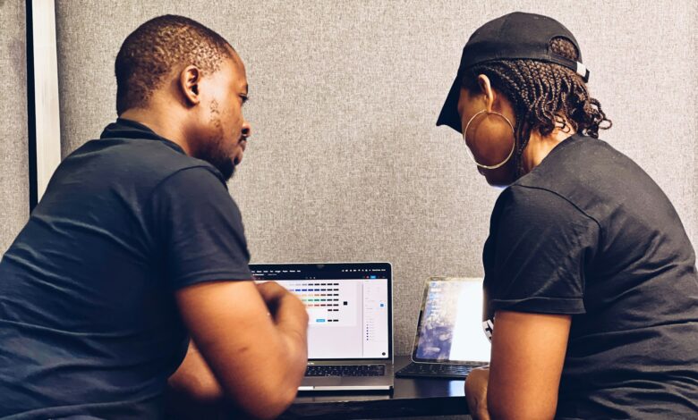 Two small business professionals reviewing cybersecurity measures on a laptop as they discuss layered security beyond traditional antivirus protection.