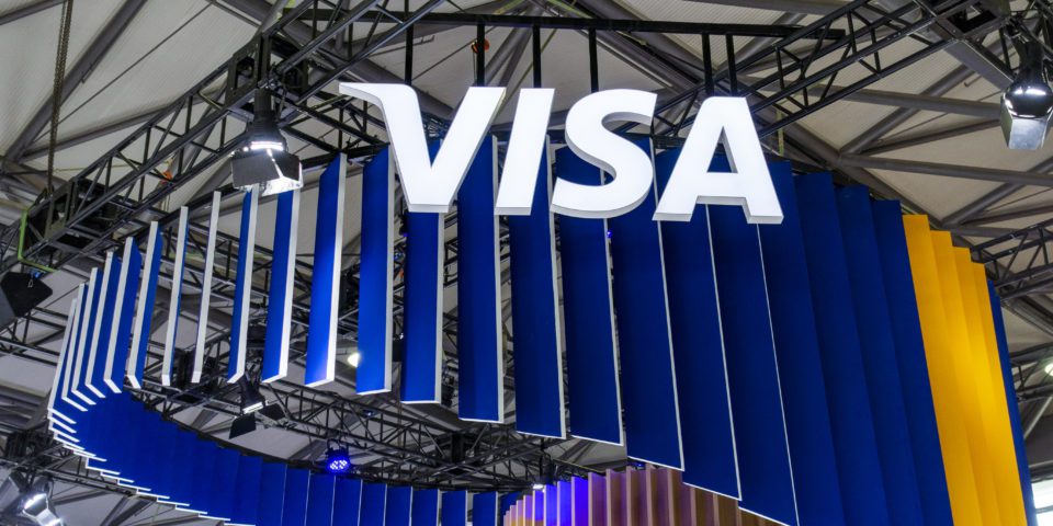 Visa logo displayed above a branded exhibition booth at a technology and payments industry event.
