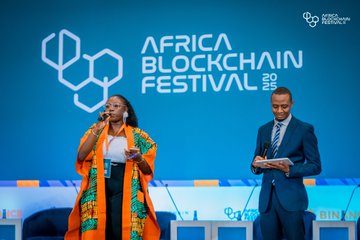 Speakers on stage at the Africa Blockchain Festival in Kigali with the event logo displayed on a large blue backdrop.