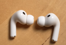 Apple AirPods Pro earbuds on a wooden surface.