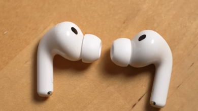 Apple AirPods Pro earbuds on a wooden surface.