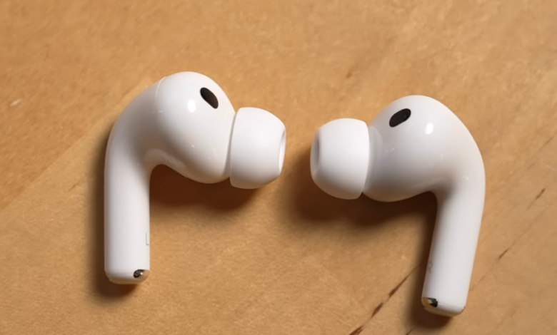 Apple AirPods Pro earbuds on a wooden surface.