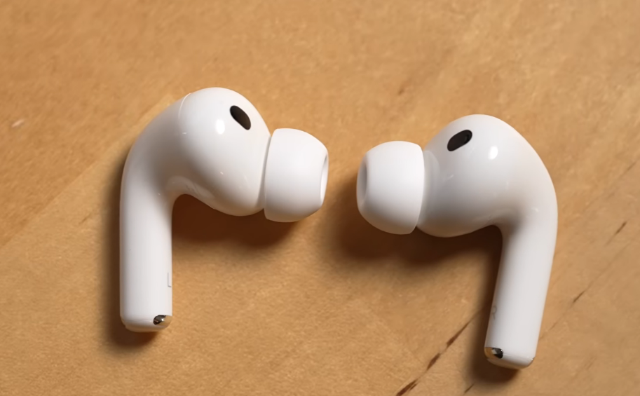 Apple AirPods Pro earbuds on a wooden surface.