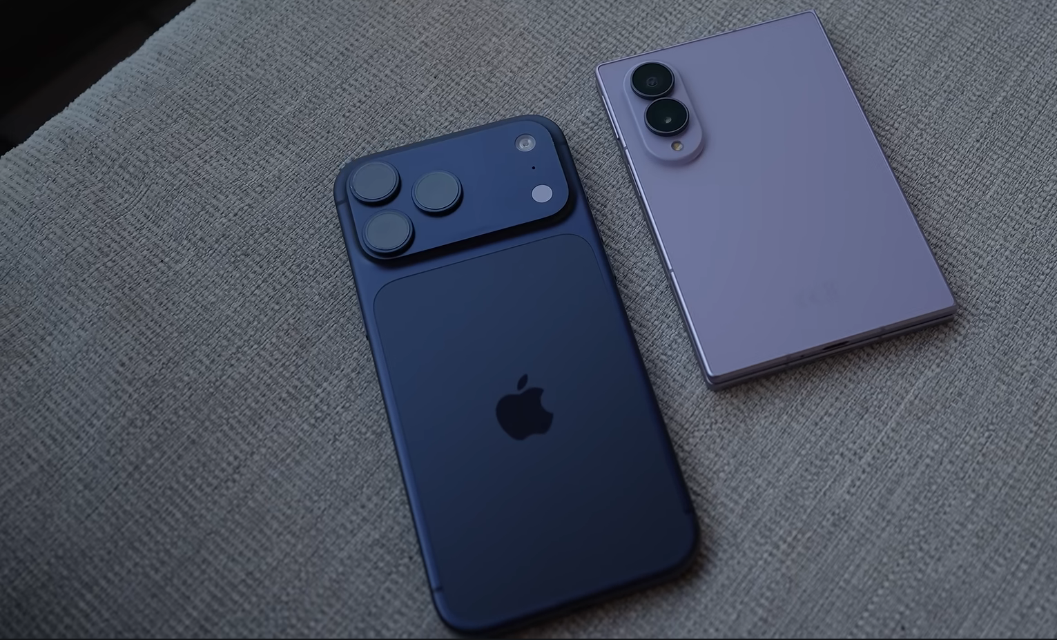 Apple iPhone 17 Pro beside a Samsung Galaxy Z Fold8 on a fabric surface, illustrating competition between iPhone and Android flagships.