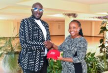 Thomas Kwaka Omolo and Hildah Maina hold a .ke branded cap during a KeNIC event promoting Kenya's local domain registrations.