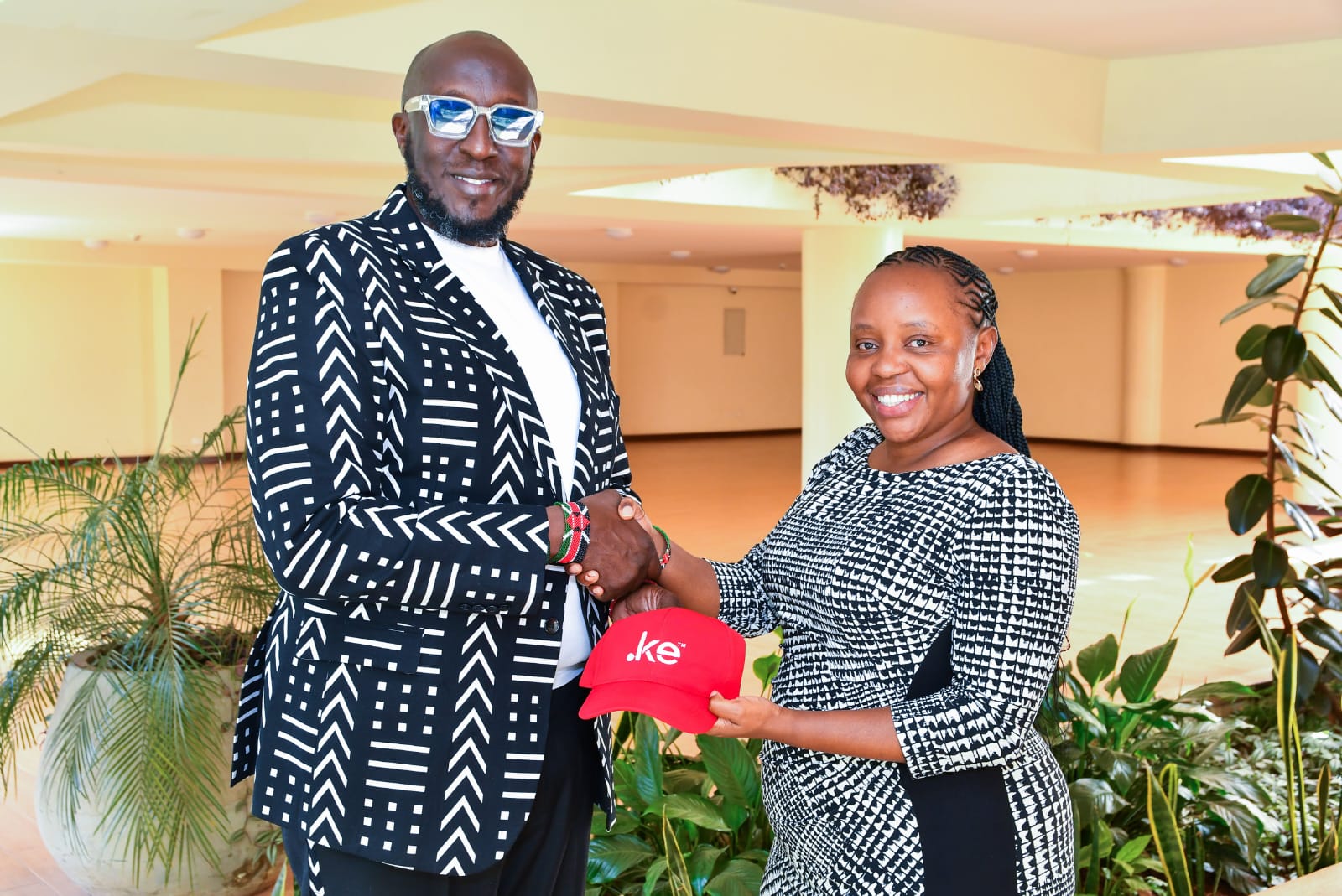 Thomas Kwaka Omolo and Hildah Maina hold a .ke branded cap during a KeNIC event promoting Kenya's local domain registrations.