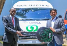NCBA and BasiGo executives beside an electric vehicle in Kenya.