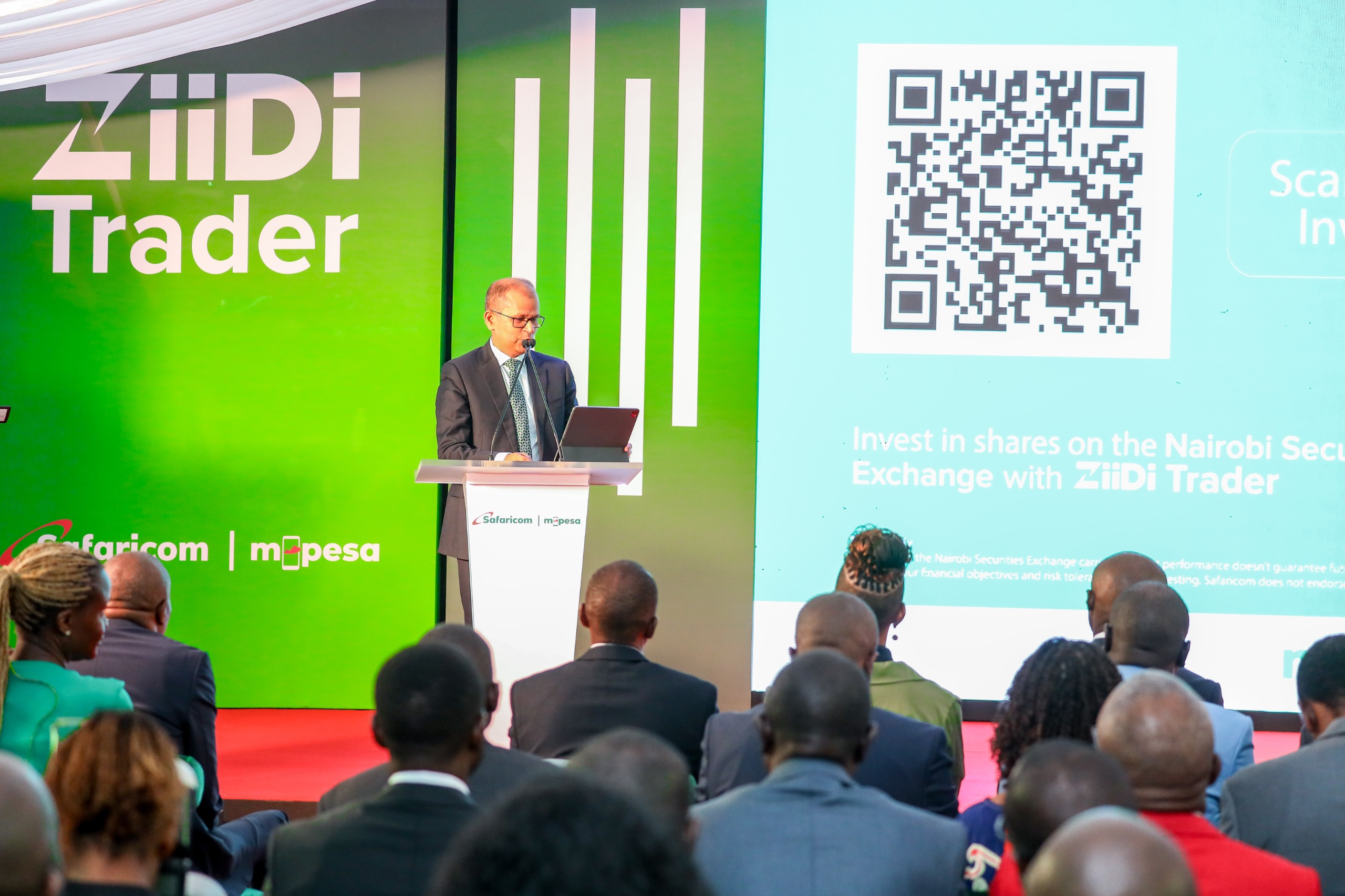 Safaricom Chief Financial Officer Dilip Pal speaks at the ZiiDi Trader launch event at the Nairobi Securities Exchange with ZiiDi Trader branding displayed behind him.