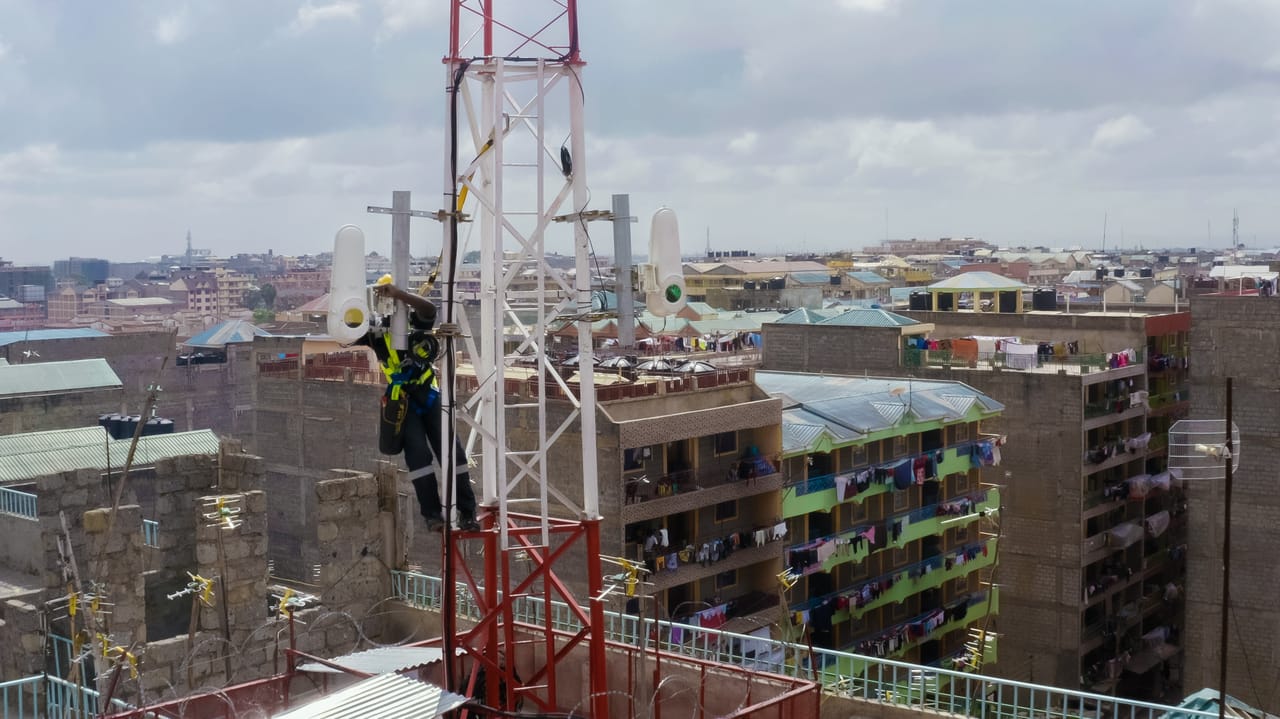 Technician installing Taara wireless optical communication equipment on a telecom tower in Lagos, Nigeria.