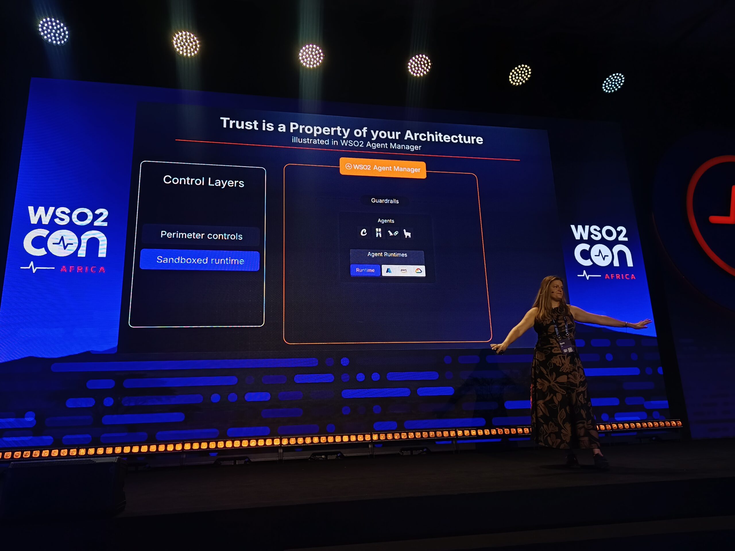Dr. Rania Khalaf presenting on stage at WSO2Con Africa 2026 in front of a slide titled 'Trusted AI Governance Needs 3 Things' showing pillars for built-in controls, AI heterogeneity, and innovation.