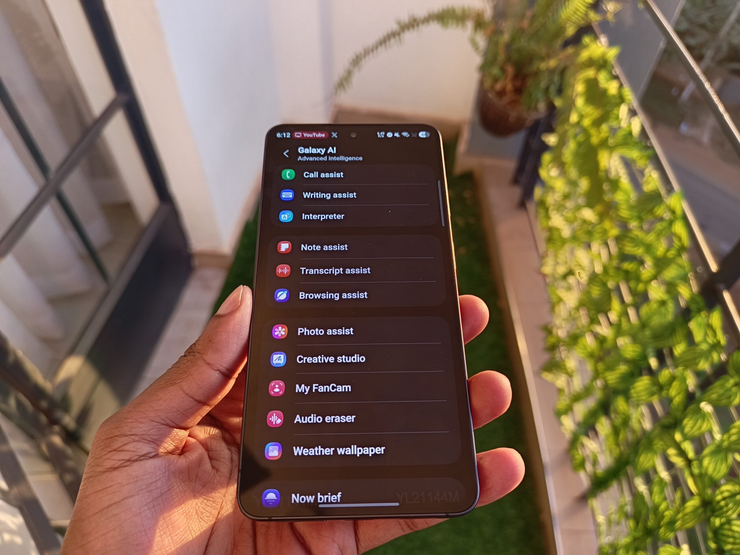 Samsung Galaxy S26 screen showing the Galaxy AI settings menu with options like Writing Assist, Photo Assist, My FanCam, and Audio Eraser.